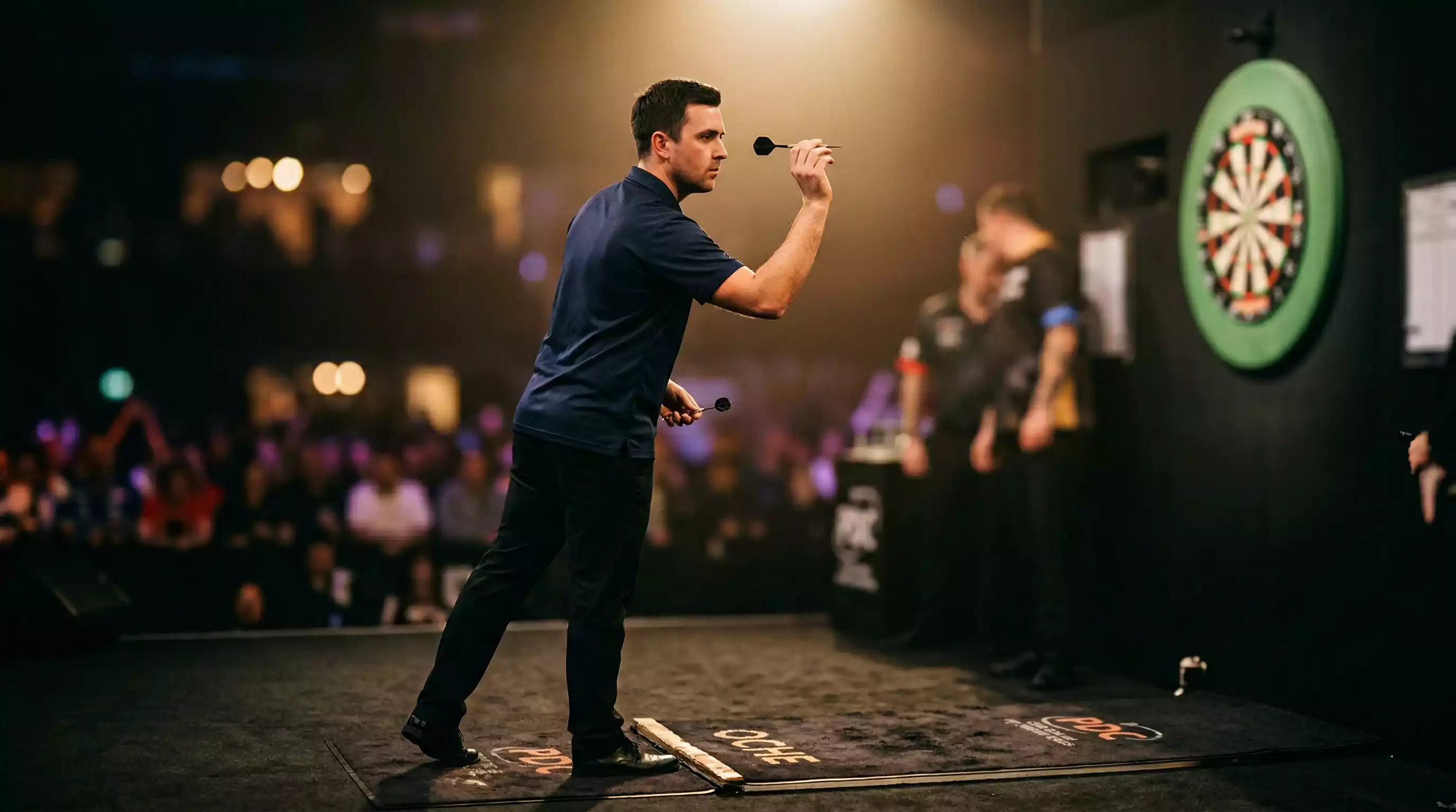 Dart Wett Tipps 2026: Professioneller Darts-Spieler am Oche im Scheinwerferlicht bei einem PDC-Turnier